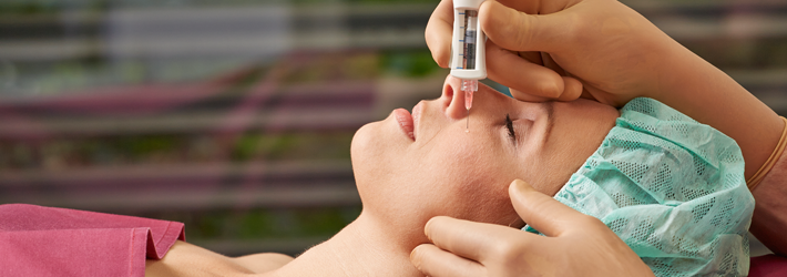 Der neuartige Hyaluron Skin Booster gibt Feuchtigkeit und Spannkraft zurück. Mit der dünnflüssigen Hyaluronsäure ergänzen die Experten der Rosenpark Klinik Faltenbehandlung und Volumentherapie. Liegende Patientin, bei der der Hyaluron Skin Booster im Gesicht angewendet wird